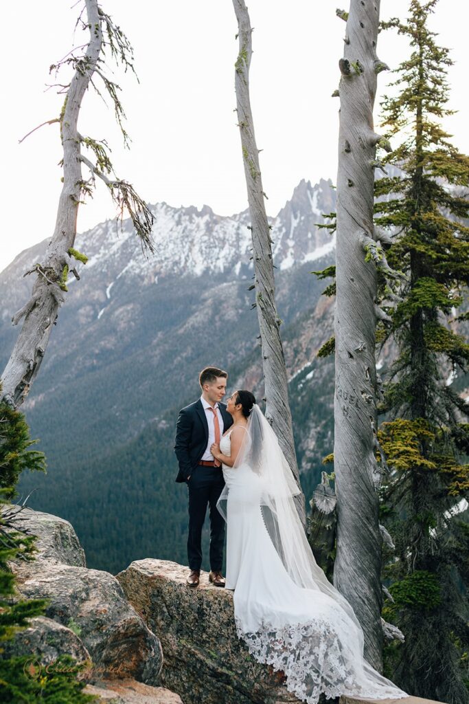 elopement couple snuggling with epic mountain views in the backdrop in the pacific north west