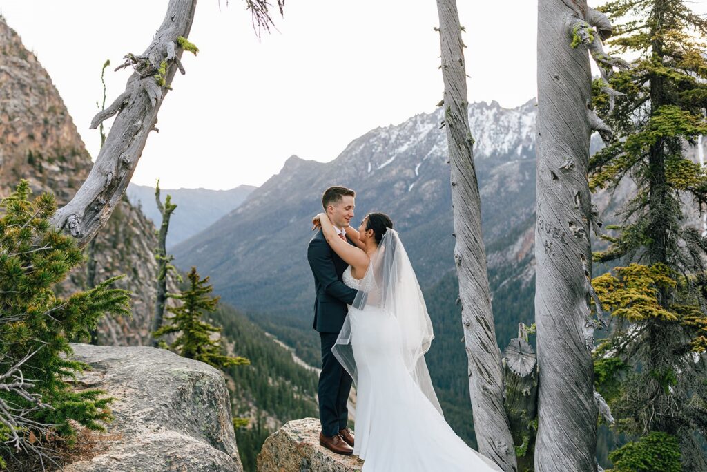 elopement couple snuggling with epic mountain views in the backdrop in the pacific north west