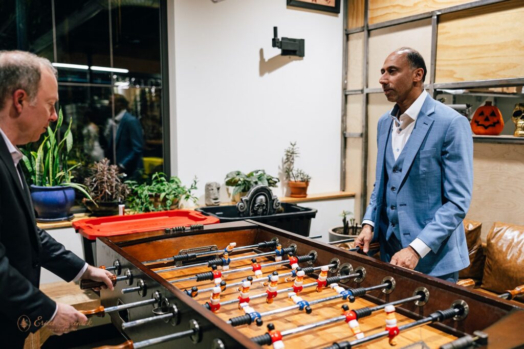 groom and friend playing table football at a brewery