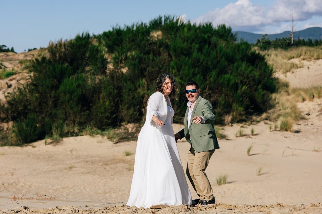 bride and groom sandboarding during their adventure elopement day in the pnw
