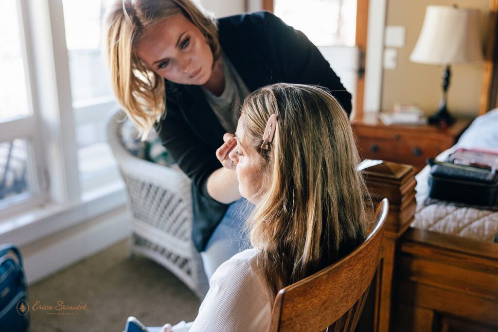 hair and make up artist helping the bride get ready for the day