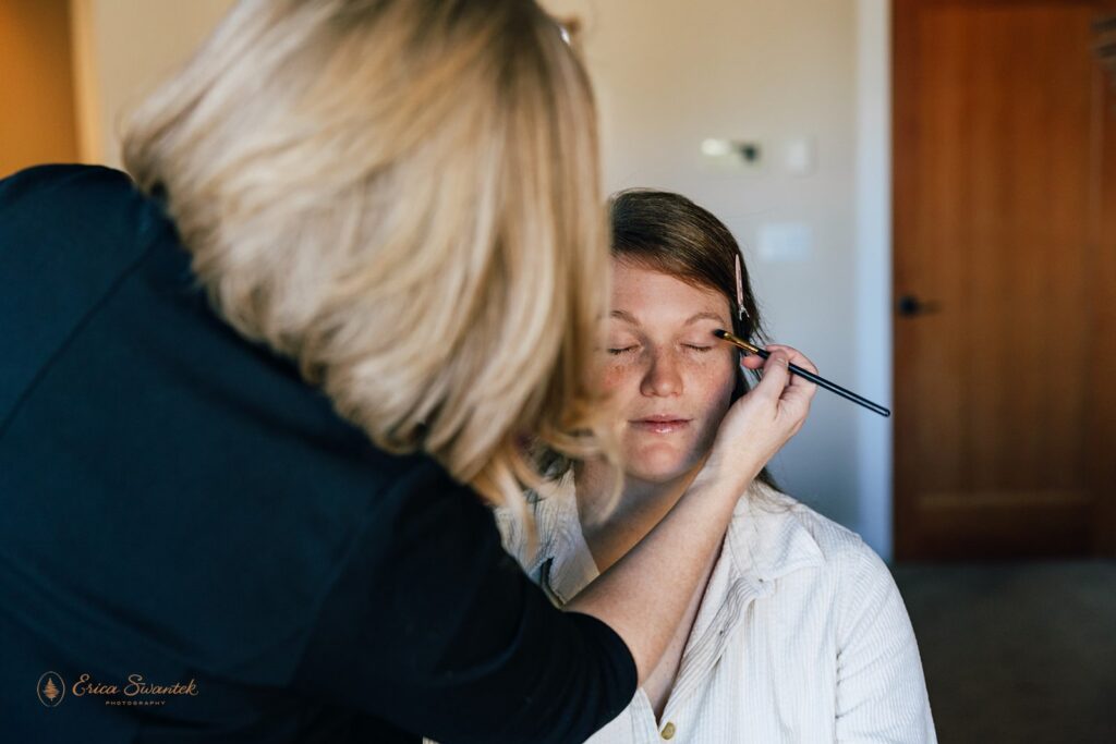 hair and make up artist helping the bride get ready for the day