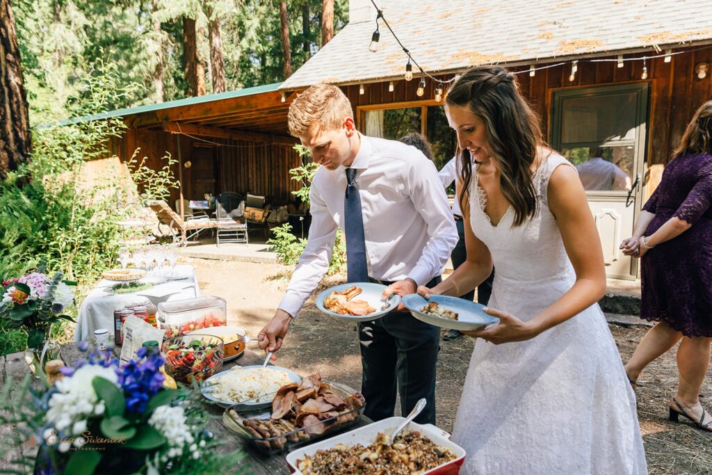 elopement couple at an outdoor buffet table
