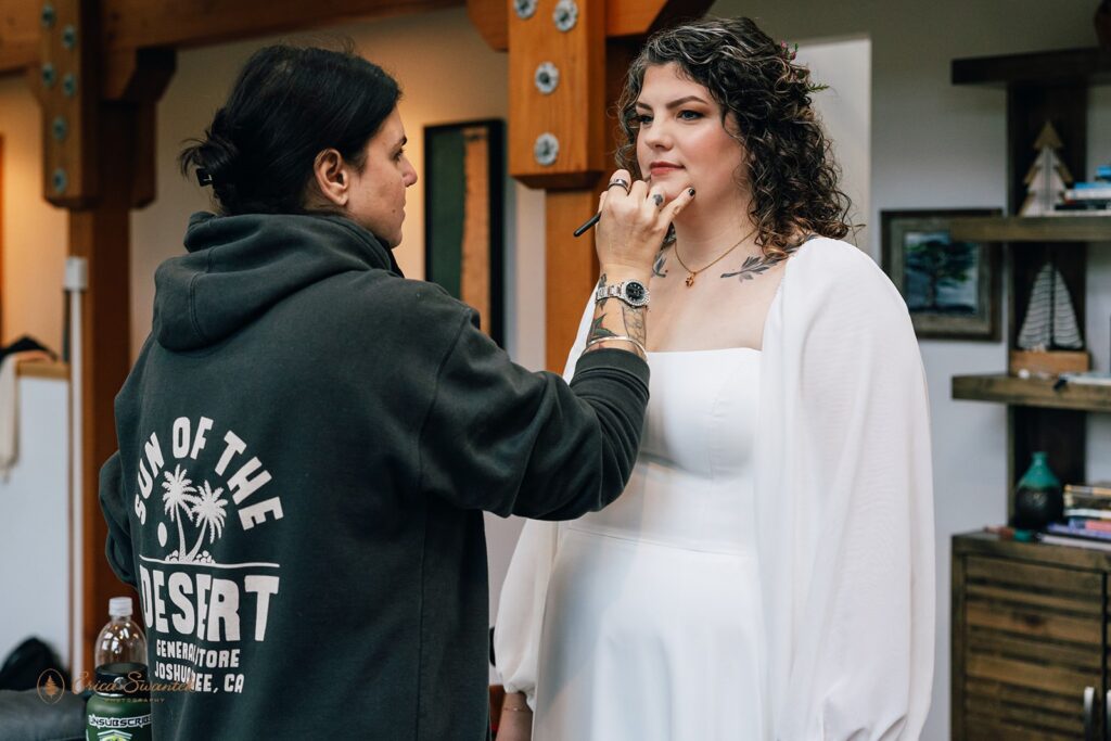 hair and make up artist helping the bride get ready for the day