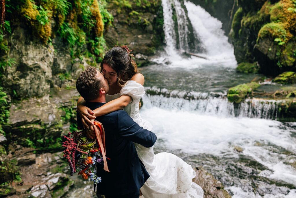 elopement couple kissing in front of virgin creek falls