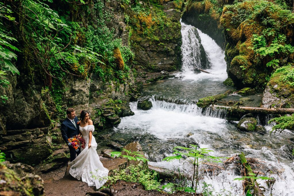 elopement couple hugging in front of virgin creek falls