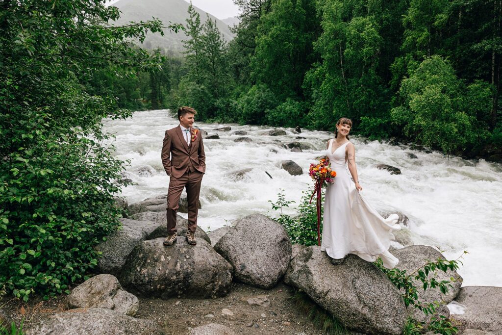 elopement couple in front of a roaring river in alaska