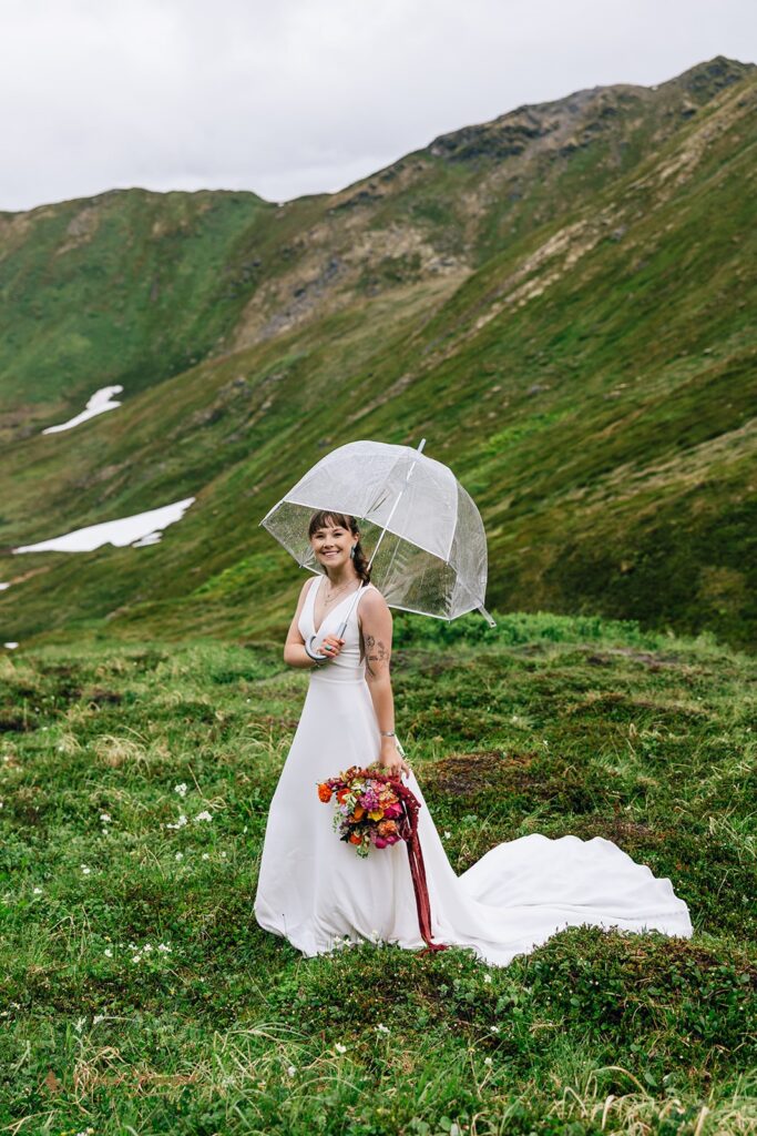 adventurous bride with a clear umbrella during a rainy elopement day in Alaska