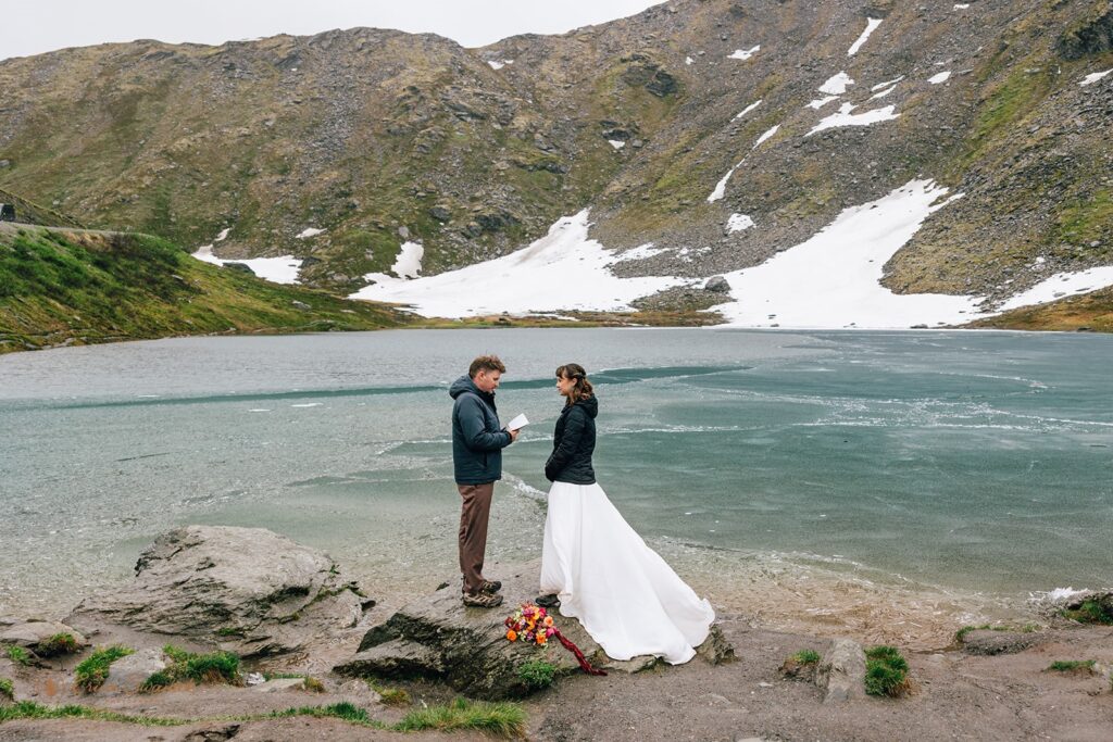 elopement couple exchanging vows in front of a frozen lake