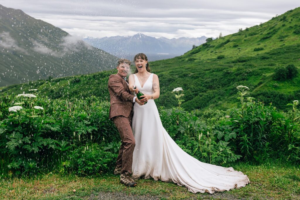 elopement couple popping champagne to celebrate their alaska elopement
